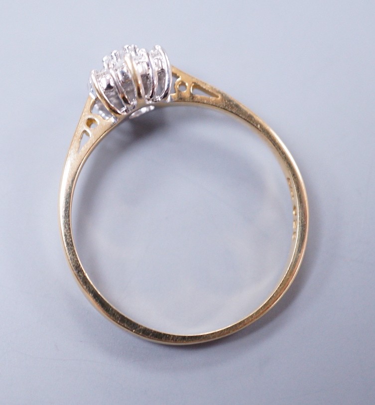A modern 18ct gold and seven stone diamond set flower head cluster ring, size P, gross weight 2.4 grams